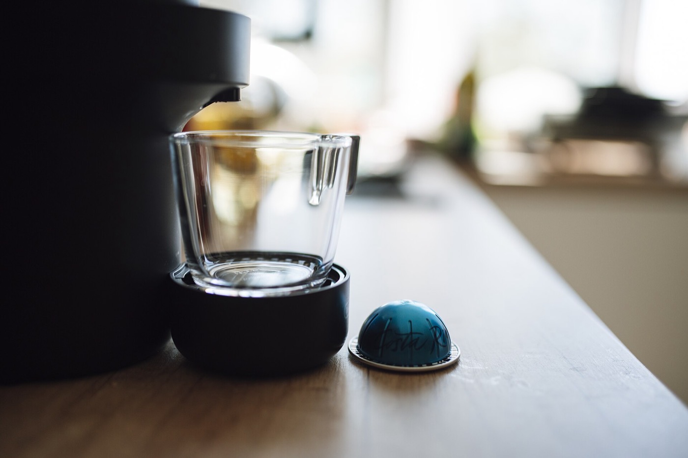 Koffiezetapparaat op een houten aanrecht met een blauw koffiecupje.